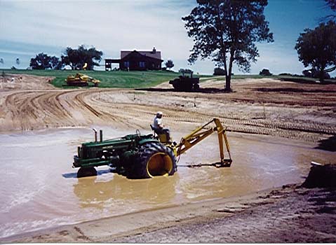 JD A with Backhoe in Pond